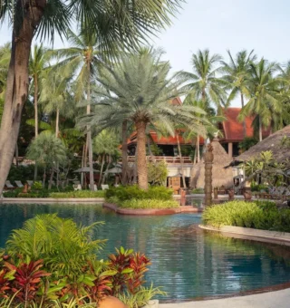 Lagoon pool shaded by coconut palms at Anantara Hua Hin Resort