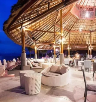 Beach restaurant under thatched roof at night at The Blue Sky Resort Koh Payam