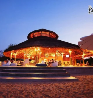 Beach bar pavilion lit at twilight at The Blue Sky Resort Koh Payam