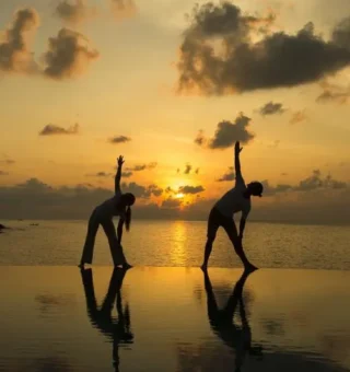 Sunset yoga on the infinity pool edge at The Villas by Kanda Residences