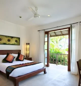 Guest bedroom opening onto a balcony at The Villas by Kanda Residences