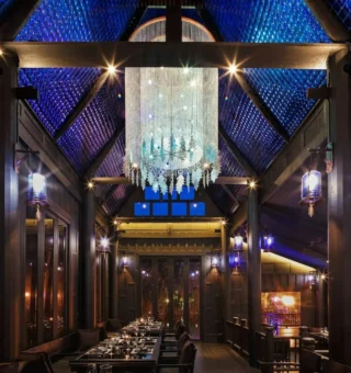 Dining hall beneath a crystal chandelier at The Slate Phuket
